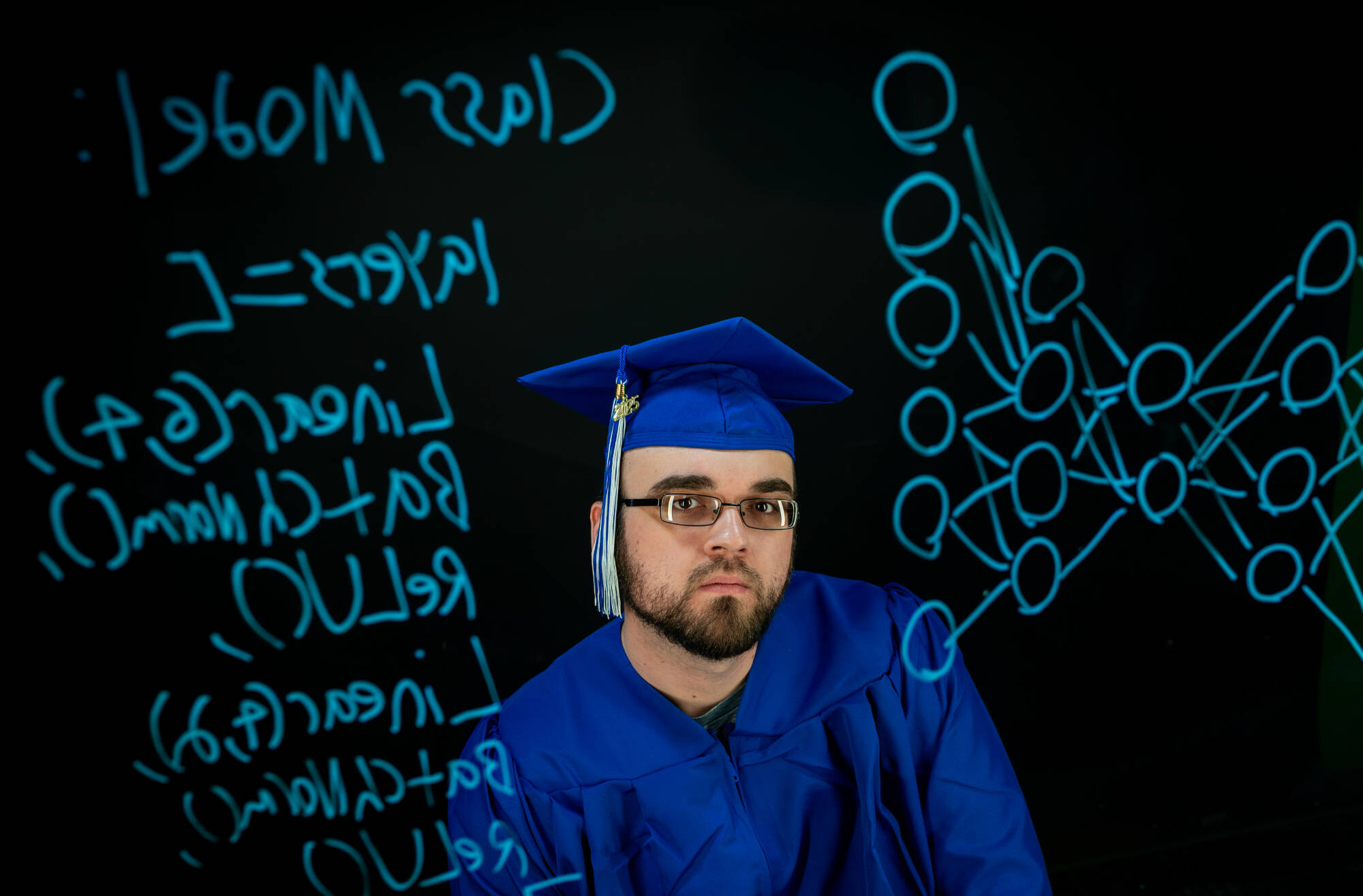 Computer Science major Anthony Boos is pictured with the Bridge Studio lightboard at the Kindschi Hall of Science on March 24. On the lightboard is a drawing of a neural network.